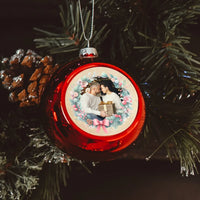 Karácsonyi piros gömbdísz ünnepi koszorúval és saját fényképpel